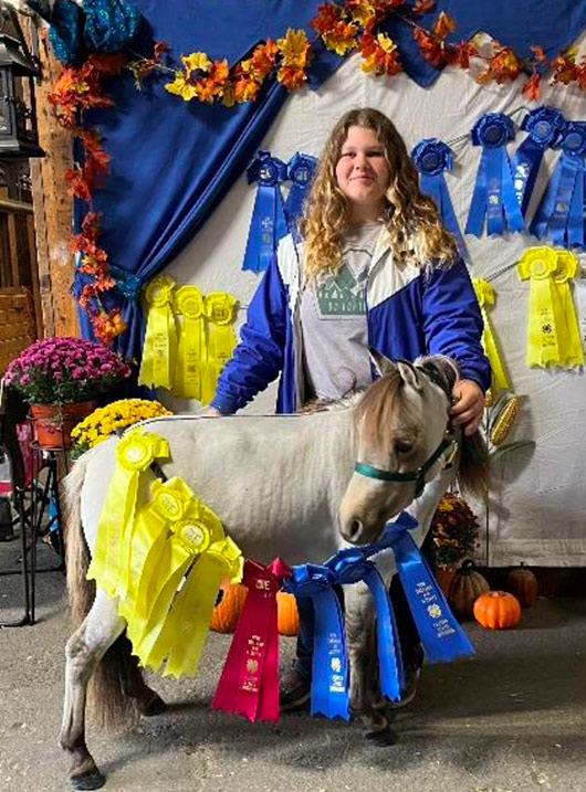 Ivy with her rosettes and miniature horse